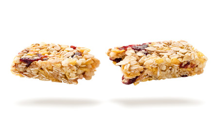 Diet granola bar broken in half flies on a white. Isolated