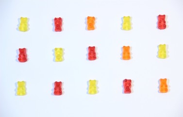 Pattern with yellow, red, orange marmalade bears on white background