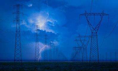 High voltage power lines with stormy sky and lightning
