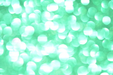 Beautiful Abstract Defocused Sparkle Glitter Lights Background. Green Emerald. Shine Bokeh Effect. For party, holidays, celebration.