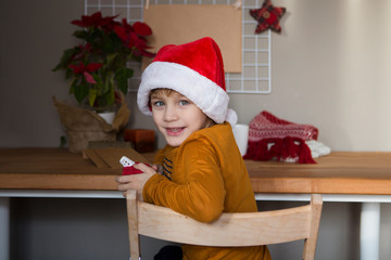 Happy child in Santa red hat Prepares gifts for Christmas. Christmas time. Eco frendly presents for Christmas. Zero waste Christmas