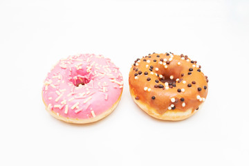 Two donuts with bright sprinkles, pink and brown, white background, top view