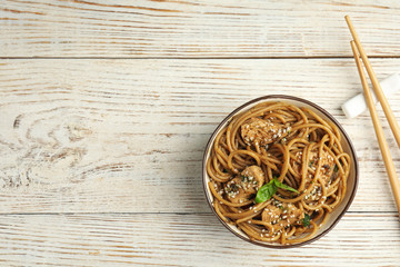 Tasty buckwheat noodles with meat on white wooden table, flat lay. Space for text