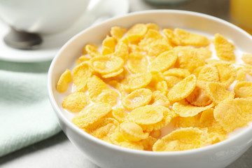 Tasty corn flakes with milk on table, closeup