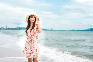 Asian young woman walk and relax on the beach