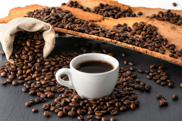 Cup of Coffee and Coffee Beans on Black Background, close-up