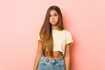 Obraz premium Young slim woman blows cheeks, has tired expression. Facial expression concept.