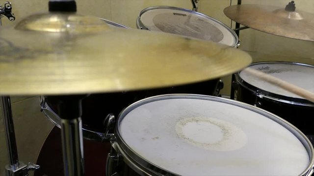 Young child plays drums on drumset