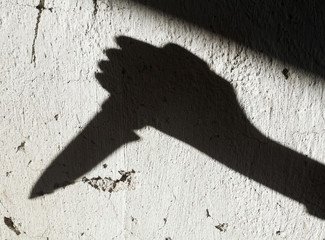 Shadow of the hand holding a knife