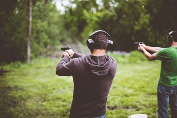 Shallow focus shot of people shotting guns in nature © Ben White/Wirestock