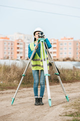Female Surveyor measuring land with digital level