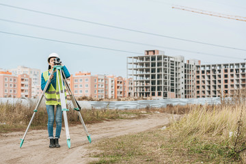 Surveyor measuring land with digital level on construction site