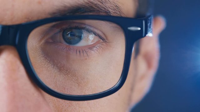 Macro blue eye of man in eyeglasses. Close up eye of businessman or student in glasses