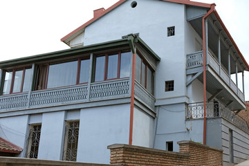 Traditional residential building in Tbilisi bottom view. Big gray house with wooden balconies