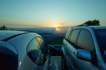 Coches aparcados reflejando el cielo al atardecer