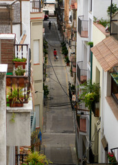 Vista aérea de una calle de un pueblo mediterráneo con una persona de espaldas