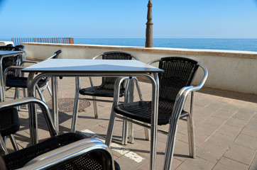 Fototapeta premium Terraza vacía con muebles de metal en un entorno de playa..