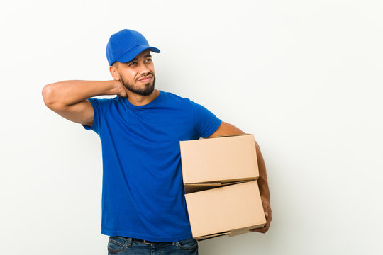 Young South-asian Delivery Man Touching Back Of Head, Thinking And Making A Choice.