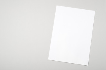 Fototapeta premium Blank white paper sheet for mock up on a gray background
