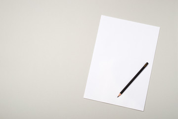 Blank paper sheet and pencil for mock up on a gray background