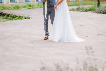 Obraz premium Wedding in the style rustic. The bride and groom in summer outdoor. Groom embracing bride. Girl puts her hand on men's shoulder, in green park.