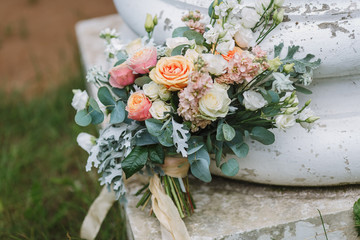 Beautiful wedding bouquet. Rose, pink, green and Peach. Trendy and modern wedding flowers outdoors