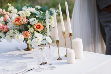 Wedding decoration table in the garden, floral arrangement, In the style vintage & rustic on outdoor. Decorated white table with yellow flowers, served for two people. Fine art laying. Family romantic