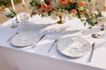 Wedding decoration table in the garden, floral arrangement, In the style vintage & rustic on outdoor. Decorated white table with yellow flowers, served for two people. Fine art laying. Family romantic
