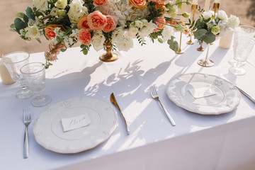 Wedding decoration table in the garden, floral arrangement, In the style vintage & rustic on outdoor. Decorated white table with yellow flowers, served for two people. Fine art laying. Family romantic