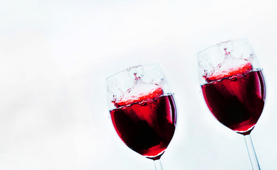 A glass in which is poured red wine on abstract background. Space for  text