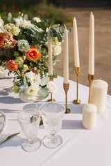 Wedding decoration table in the garden, floral arrangement, In the style vintage & rustic on outdoor. Decorated white table with yellow flowers, served for two people. Fine art laying. Family romantic