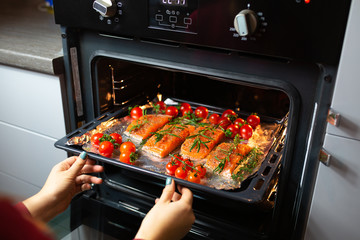 Cooking salmon in the oven. Housewife is preparing dinner. The chef is cooking red fish. Cooking...