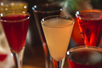 Set of glasses with different colored tinctures made on the basis of fruits and alcohol, a...