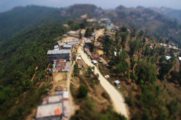Pokhara, Nepal - April 1, 2014: View from a paraglider to the valley and Lake Pheva in Pokhara, Himalayas. Rice fields, mountains and small houses. Tilt Shift Effect