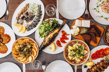 large wooden table with mouthwatering national Russian dishes. The restaurant where the food is...