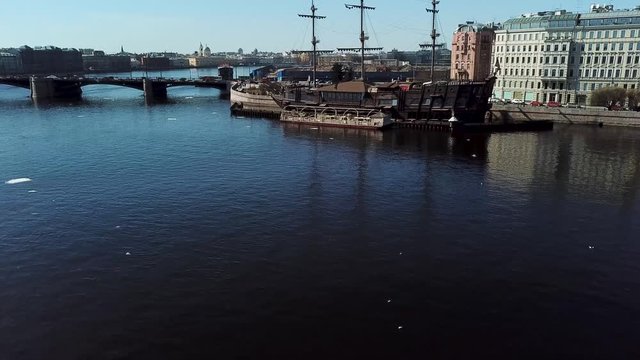 Aerial view of an old frigate moored in Neva river, St. Petersburg, Russia. Stock footage. Breathtaking panoramic landscape of the city, bridge, and embankment.