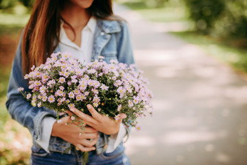 Beautiful woman in park with bouquet of flowers