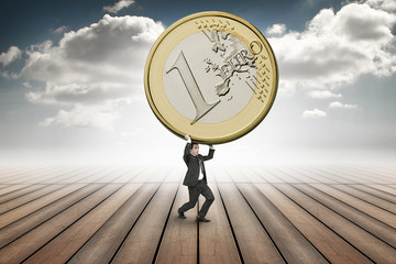 businessman is lifting up a huge euro coin