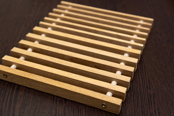 On a dark table lies a lattice of wooden dice connected by inserts.