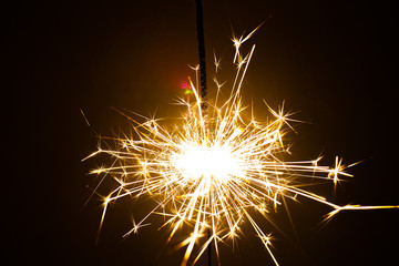 Sparkler in honor of the holiday on a black background. Merry Christmas