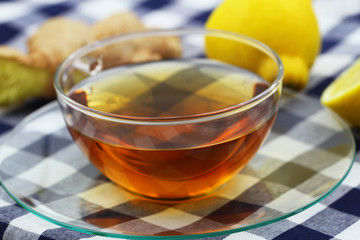 Cup of tea, fresh ginger root and juicy lemon, closeup