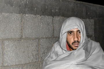an hungry homeless beggar man wearing shawl and his eyes are full of pain