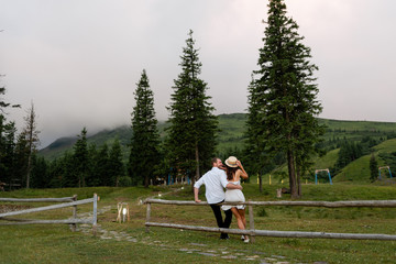 Fototapeta premium A guy and a girl sit and look at the forest landscape