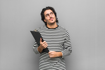 Young employee man holding an inventory dreaming of achieving goals and purposes