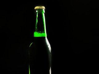 Green bottle with beer on black background