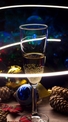 A glass of champagne on the Christmas decorations. happy New Year. Christmas composition. 2020. Christmas toys and lights garlands. Restaurant, bar party, light show.
