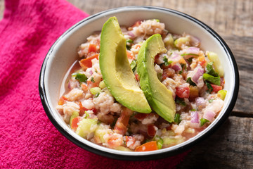 Mexican fish  ceviche with avocado on wooden background