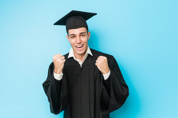 Young caucasian graduated man cheering carefree and excited. Victory concept.