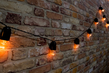 garland of lamps on a brick background.