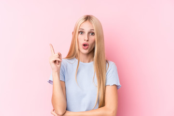 Young blonde woman on pink background having some great idea, concept of creativity.